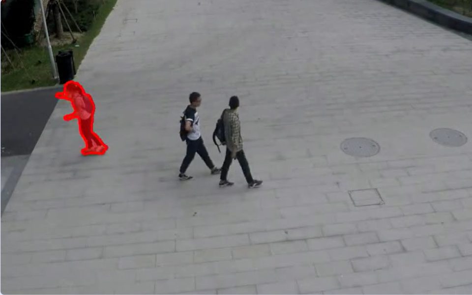 A ShanghaiTech campus walkway with an anomalous cyclist masked in red by GridVAD